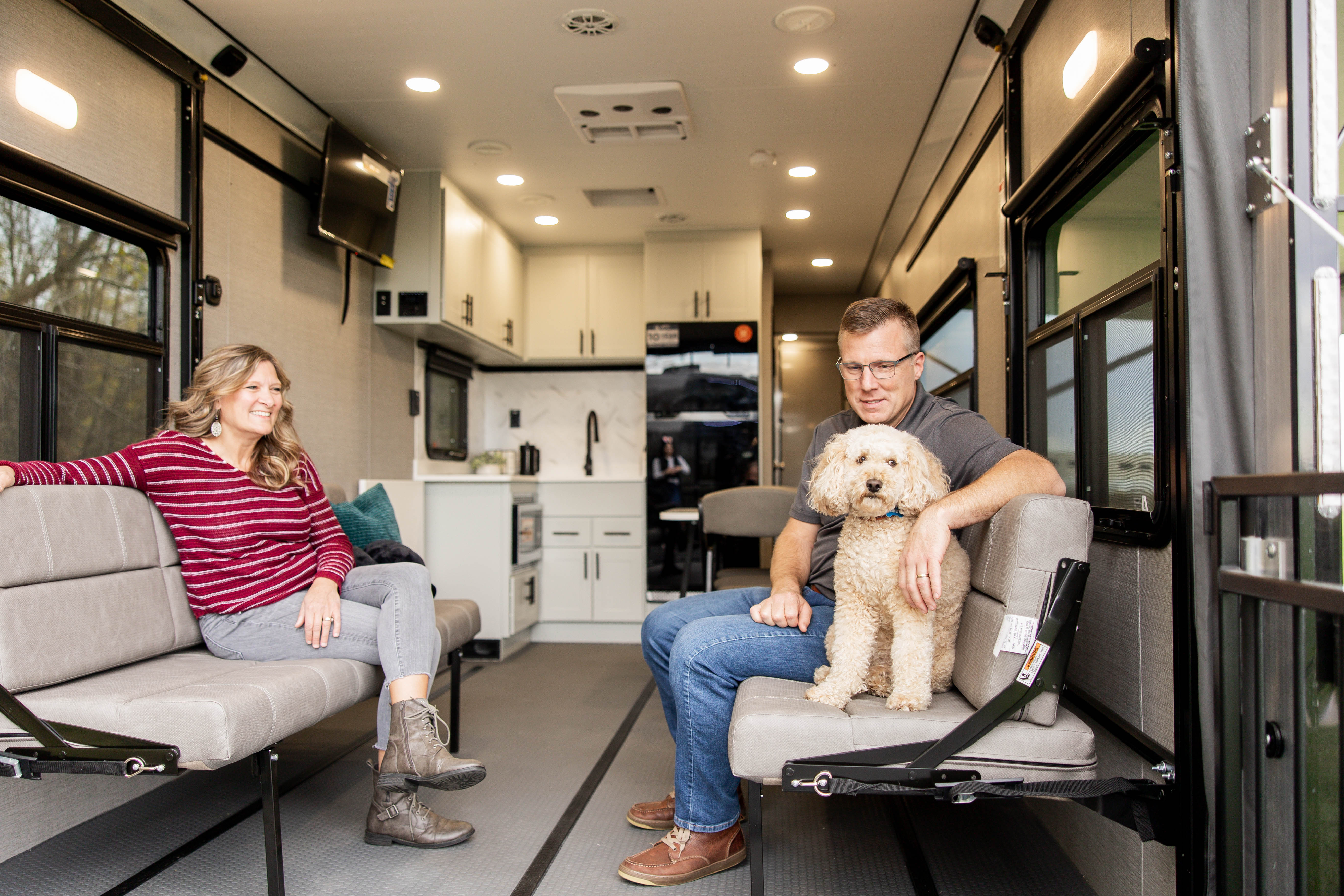 Photo of a couple and dog inside the garage of an ATC toy hauler.